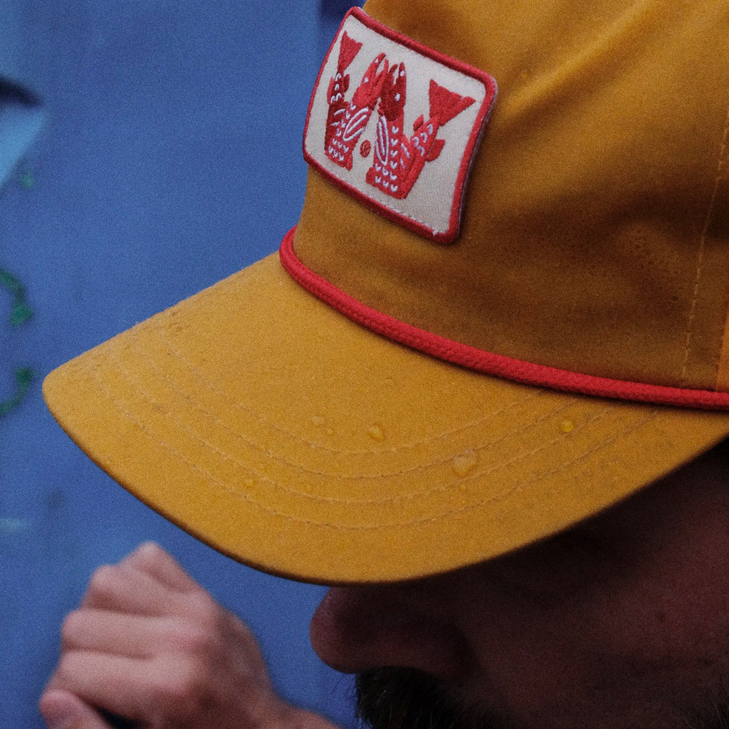 Yellow cap with a red and white logo on a blue background