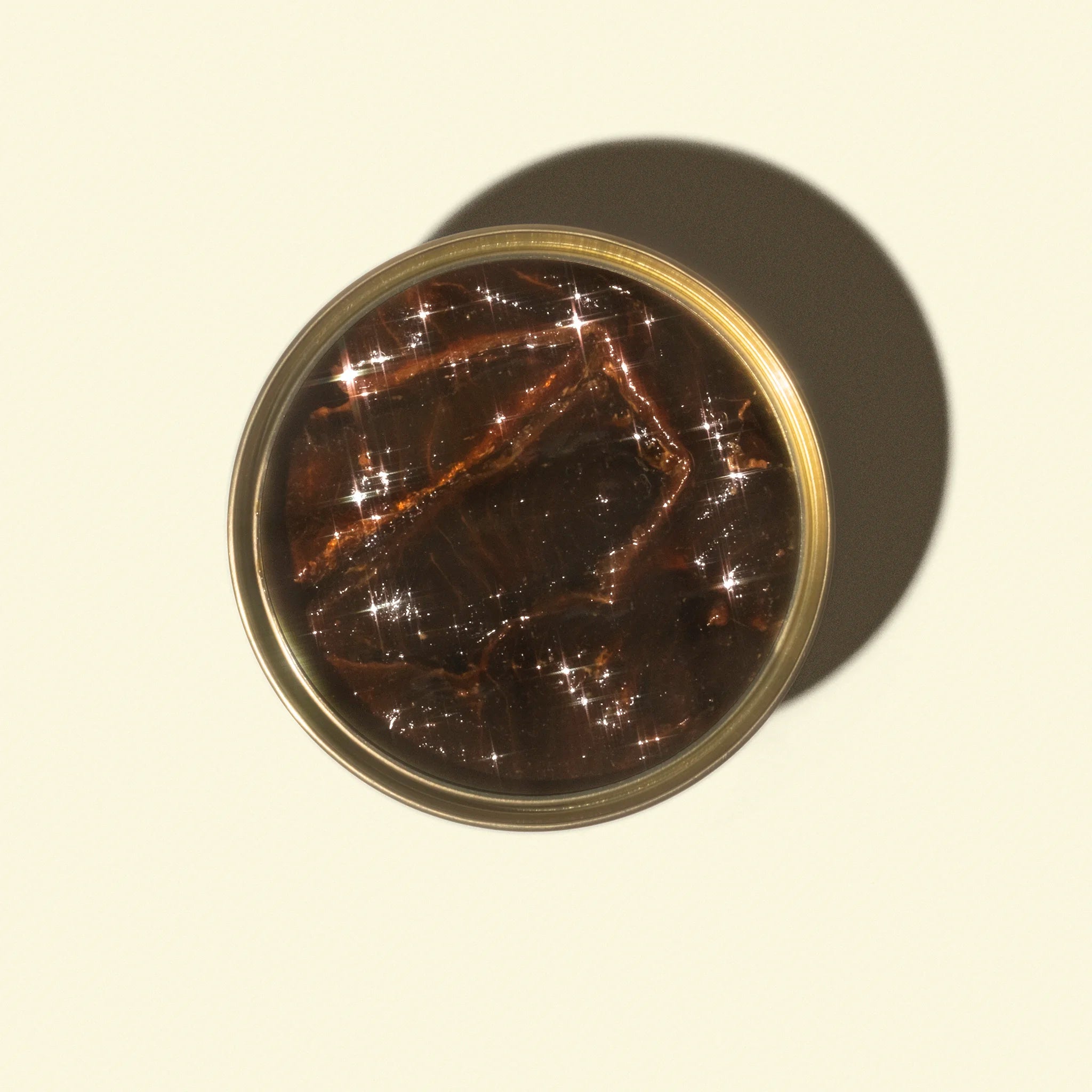 Round container with a reflective surface on a beige background