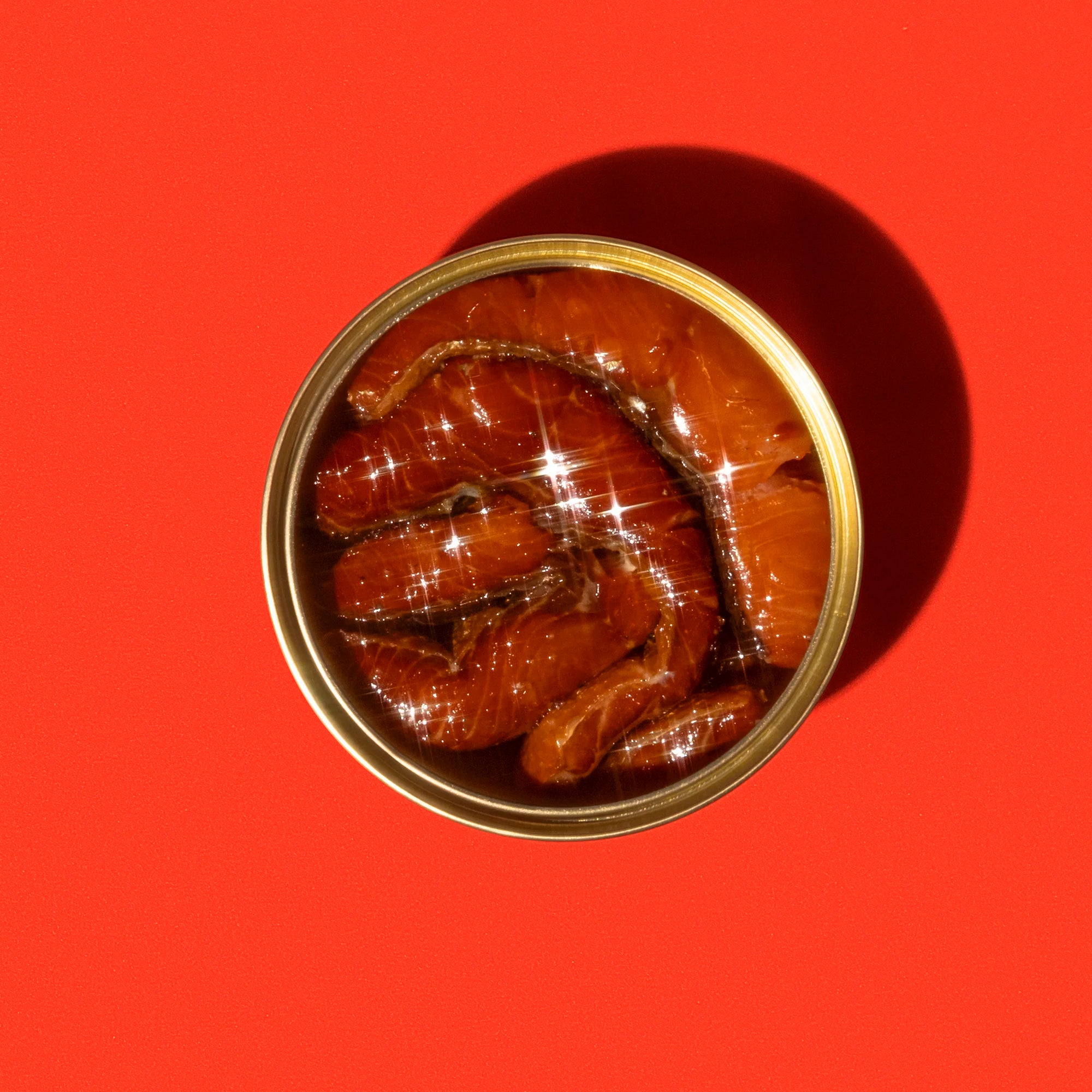 Open can of smoked sockeye on a red background